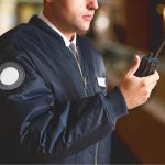 Man in Uniform communicating through handheld walkie talkie