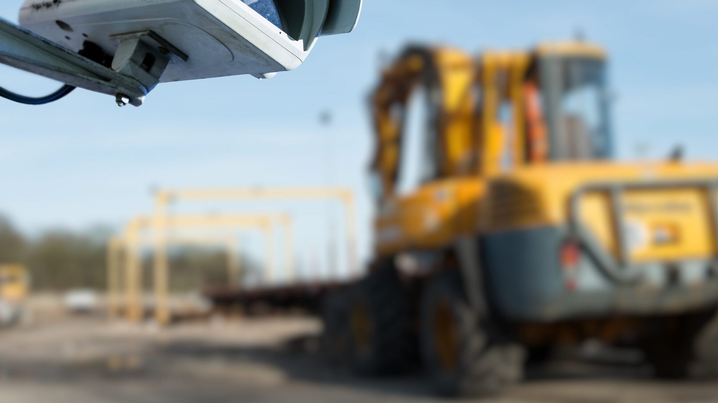 CCTV camera in the foreground of heavy construction machine