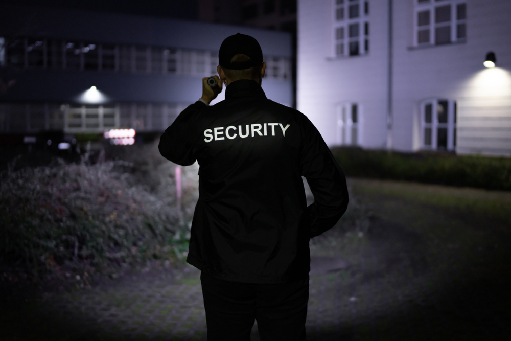 Security Guard Walking around a building at night